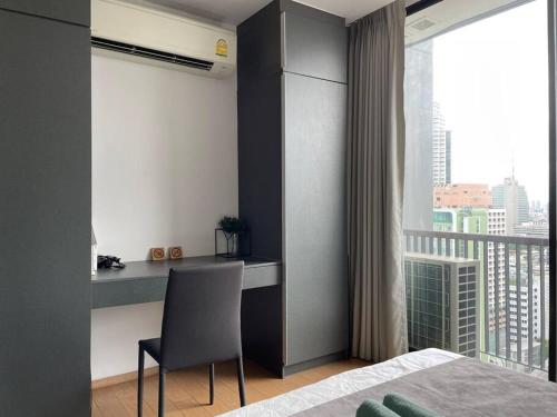 a bedroom with a desk and a chair and a window at Private room with 1 Bedroom & 1 Bathroom, near BTS Surasak in Bangkok
