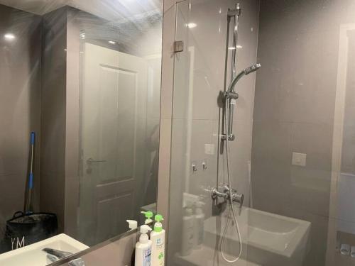 a bathroom with a shower and a sink and a mirror at Private room with 1 Bedroom & 1 Bathroom, near BTS Surasak in Bangkok