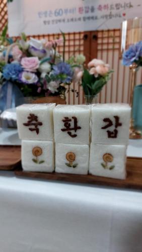 a group of four sushi rolls on a table with flowers at Dongmyo Hanok Sihwadang - Private Korean Style House in the City Center with a Beautiful Garden in Seoul