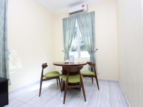a dining room with a table and chairs and a window at Aloha Chalet in Kampung Raja