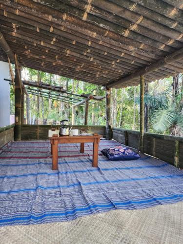 a wooden table sitting on a rug on a patio at D'flora Bungalow & Glamping in Noca