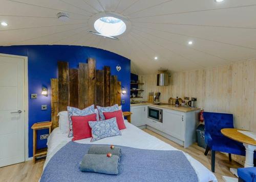 a bedroom with a large bed and a blue wall at Mallory Meadows in Kirkby Mallory