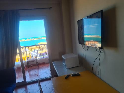uma sala de estar com uma televisão de ecrã plano e uma mesa em PORTO MARINA North Coast -الساحل الشمالي بورتو مارينا العلمين em El Alamein