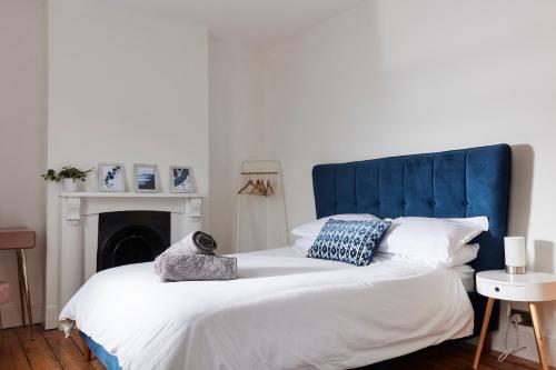 a bed with a blue headboard and pillows on it at 13 Oxford Street in Exeter