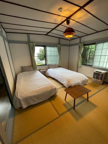 sypialnia z 2 łóżkami i stołem w obiekcie NewOpen FreeParkingOtaru小樽湾一望ハウスOkanoue House戸建 w mieście Otaru