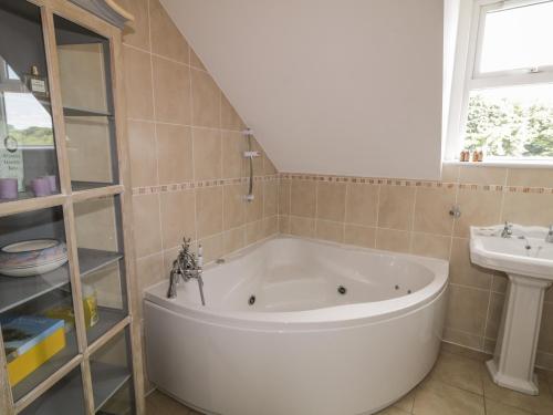 a bathroom with a large tub and a sink at The River House in Ramelton