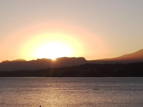 um pôr-do-sol sobre a água com montanhas ao fundo em Nueve Lunas em Temuco