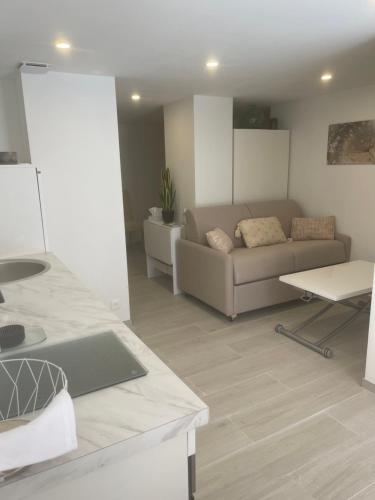 een woonkamer met een bank en een tafel bij Grand studio neuf à 50 m du port in Saint-Tropez