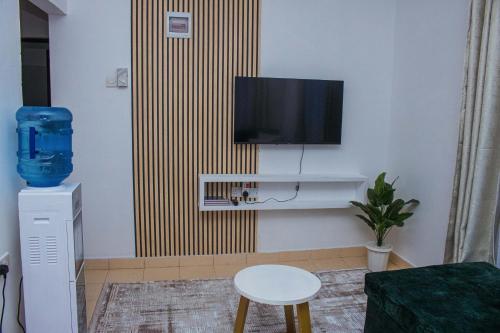 un salon avec une télévision à écran plat fixée au mur dans l'établissement Joyous Homes, à Mombasa