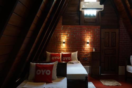 a room with two beds and a brick wall at Another World Hostel Sigiriya in Sigiriya