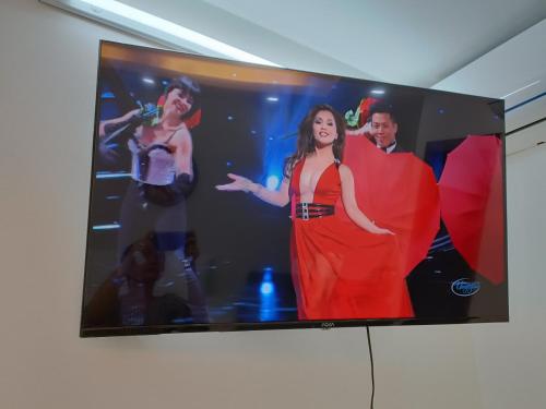 a tv screen with a woman in a red dress at Best Studio Room Near Ben Thanh Market in Ho Chi Minh City