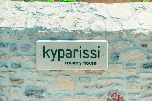 Uma placa numa parede de tijolos que diz: em Kyparissi Country House em Marmaroto