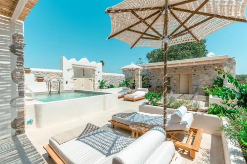a patio with an umbrella and a swimming pool at Kyparissi Country House in Marmaroto