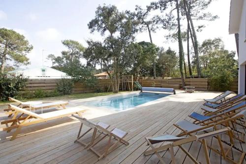une terrasse avec des chaises et une piscine dans l'établissement Superbe villa 5* avec piscine chauffée, à Labenne