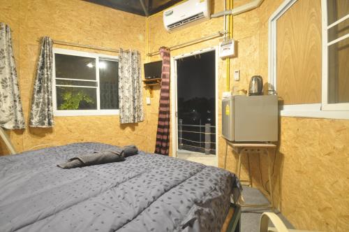 a bedroom with a bed and a kitchen and a window at ayutthaya river camp and yacht charter in Ban Khlong Suan Phlu