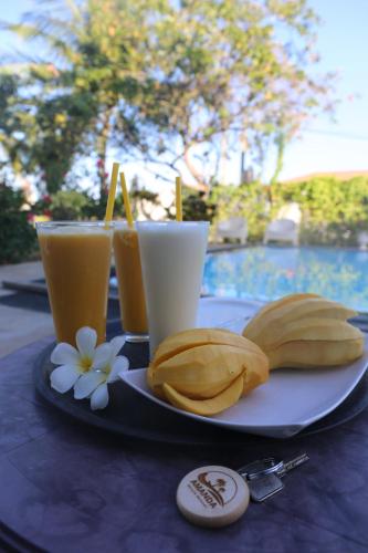 a plate with banana slices and two drinks on a table at Amanda Beach Resort in Pasikuda