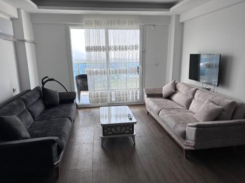 a living room with a couch and a coffee table at App. Meeres Blick Eşin Golf Resort in Soke