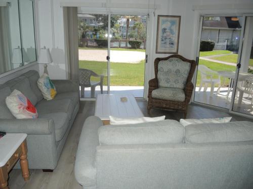 una sala de estar con 2 sofás y una silla en Golf Resort Villa 1503 Steps to Pool, en Calabash