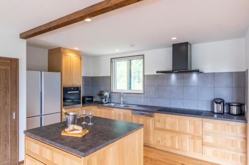 a kitchen with wooden cabinets and a black counter top at SANGA HOUSE in Kutchan