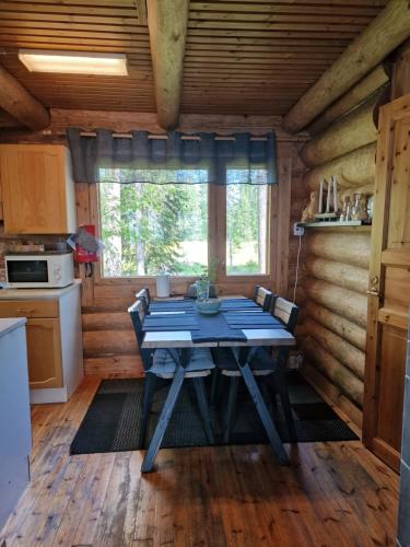 a dining room with a table in a log cabin at Vacation Home Tulikallio in Suonenjoki
