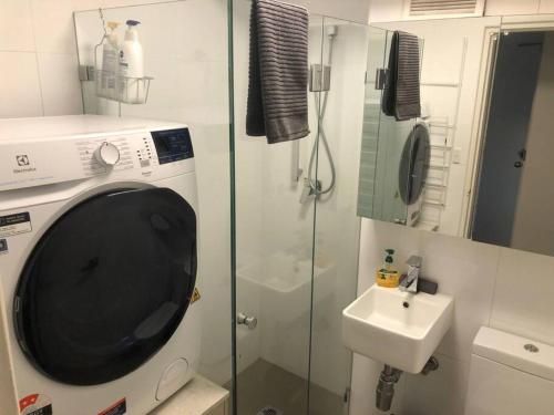 a bathroom with a washing machine and a sink at Lovely refurbished 1 bed near marina + parking in Sydney
