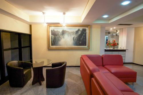 a waiting room with a couch and a glass table at Bristol Metropolitan Curitiba Centro in Curitiba