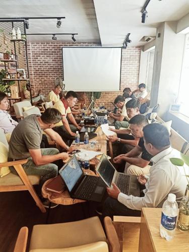a group of people sitting at tables with laptops at Hoa Sua Hotel in Vung Tau