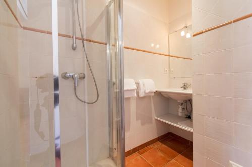 y baño con ducha y lavamanos. en Casa Vecchia rooms + apartments, en Calvi