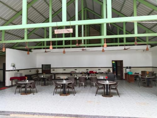 a room with tables and chairs in a building at UVA Sands Beach Resort in Kundapur