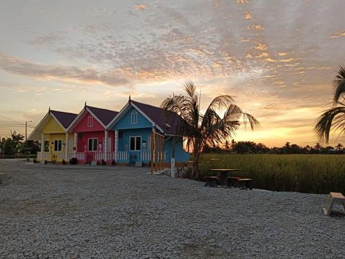 una fila de casas en la playa al atardecer en Laman D'Arni, en Sungai Besar