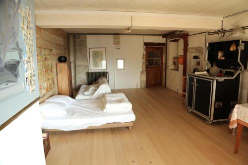 een slaapkamer met een bed in een kamer met houten vloeren bij la Commanderie in Le Poët-Laval