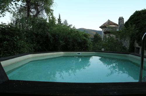 een groot zwembad van blauw water in een tuin bij la Commanderie in Le Poët-Laval