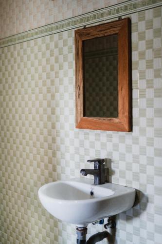 a white sink in a bathroom with a mirror at Kayuma House Canggu in Canggu