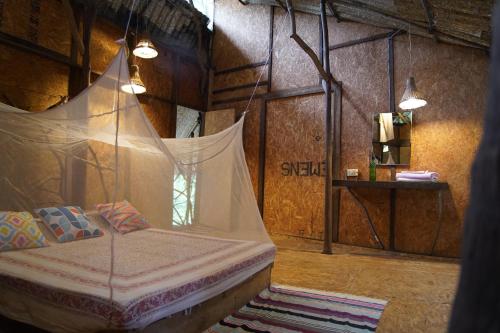a bedroom with a bed with a mosquito net at Saraya in Sangolda