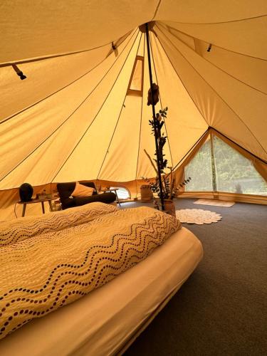 a large tent with a bed in a room at Glamping on idyllic lake, paddle boards & rowboat in Porsgrunn
