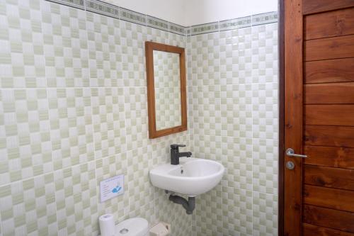 a bathroom with a sink and a mirror on the wall at Kayuma House Canggu in Canggu