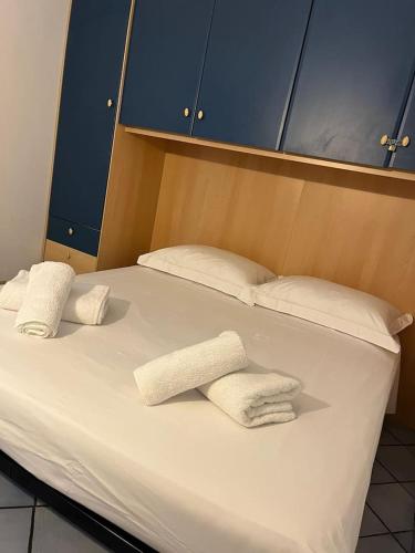 - un grand lit blanc avec 2 serviettes blanches dans l'établissement Dragonniere, Superbe 2P vue parc et piscine, près de Monaco, à Roquebrune-Cap-Martin