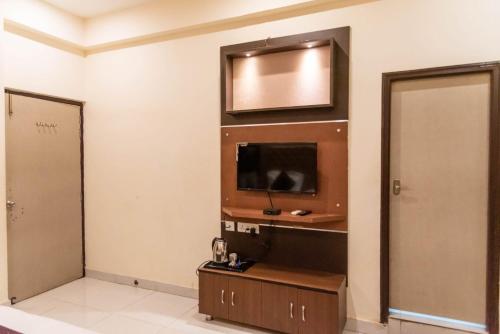 a room with a flat screen tv and a door at Maple Delite in Lucknow