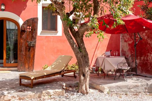 a tree and a chair next to a table with an umbrella at Hotel Villa Sermolli in Borgo a Buggiano