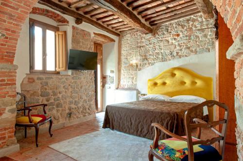 a bedroom with a bed in a brick wall at Hotel Villa Sermolli in Borgo a Buggiano