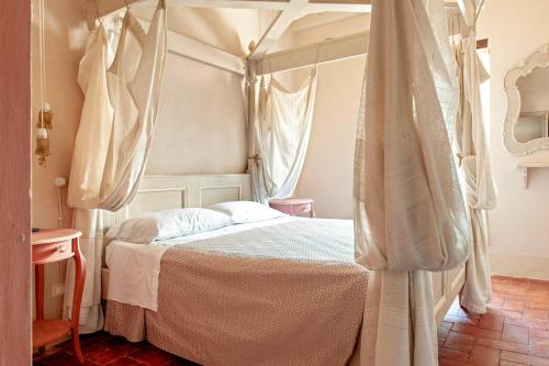 a bedroom with a canopy bed with curtains at Hotel Villa Sermolli in Borgo a Buggiano