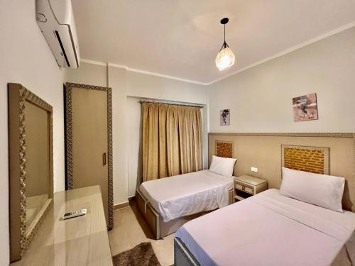 a hotel room with two beds and a mirror at Blue Residence Dahab in Dahab
