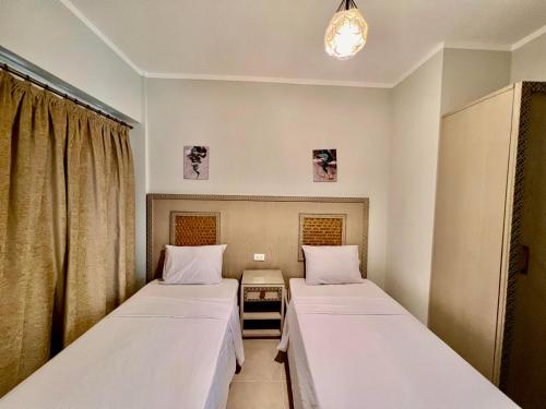 two beds in a hospital room with curtains at Blue Residence Dahab in Dahab