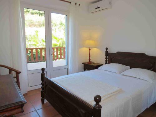 um quarto com uma cama grande e uma janela em Villa Bourbon avec piscine sur la plage em Saint-Gilles-les-Bains