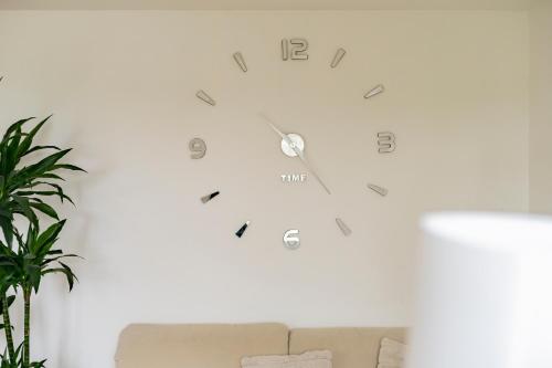a clock hanging on a wall next to a couch at Exclusive 2-Room-City-Apartment - Contactless Check-in in Hannover