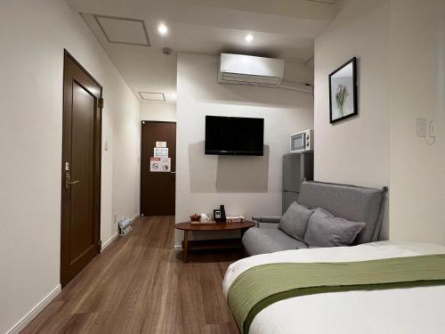 a hotel room with a bed and a couch at dandelion house in Tokyo