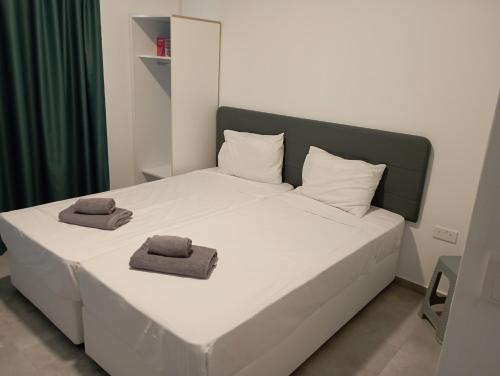 1 dormitorio con 1 cama con 2 toallas en BlueSuite en Ayia Napa