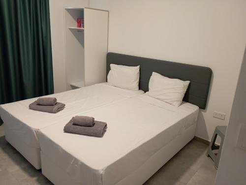 a bedroom with a bed with two towels on it at BlueSuite in Ayia Napa
