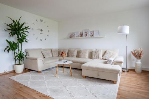 a living room with a couch and a clock on the wall at Exclusive 2-Room-City-Apartment - Contactless Check-in in Hannover