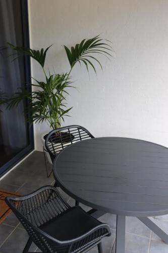 a table and two chairs and a plant in a room at Lorne Surf Apartments in Lorne